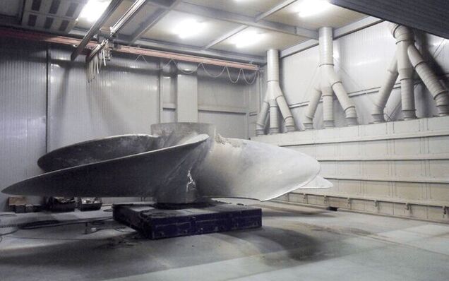 The dust produced during finishing a ship's propeller is directed to a trio of filters through an extraction panel.